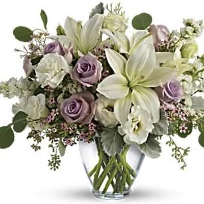 Lavender roses and white lilies in a clear glass vase