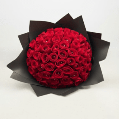 Round bouquet of red roses wrapped in black paper