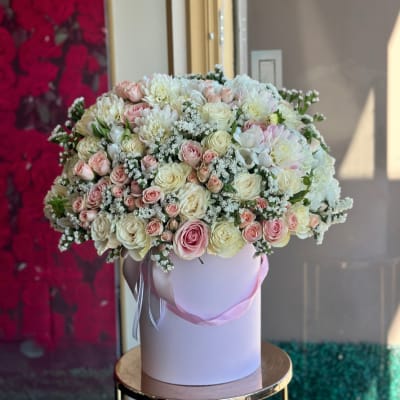 Large bouquet of pink and white roses in a round box
