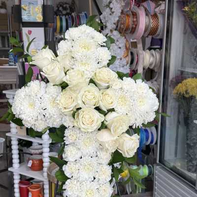 White rose and chrysanthemum cross arrangement on an easel