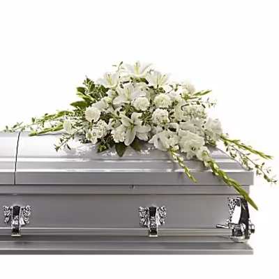 White floral casket spray with lilies and carnations