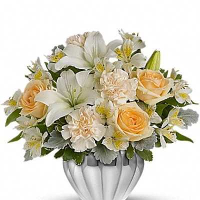 White and peach floral arrangement in a silver vase