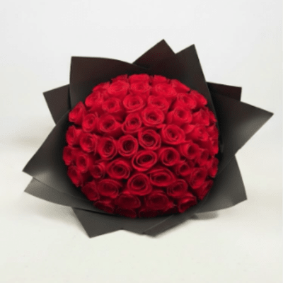 Round bouquet of red roses wrapped in black paper