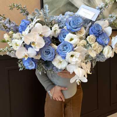 Large bouquet of blue and white roses with white orchids