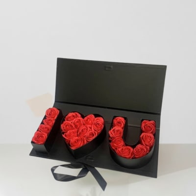 Black gift box with red roses arranged as "I love you"