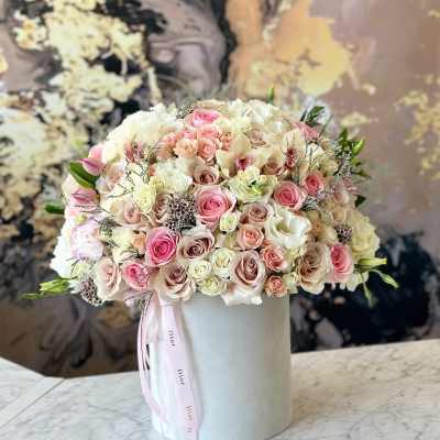 Round bouquet of pink and white roses in a white hat box