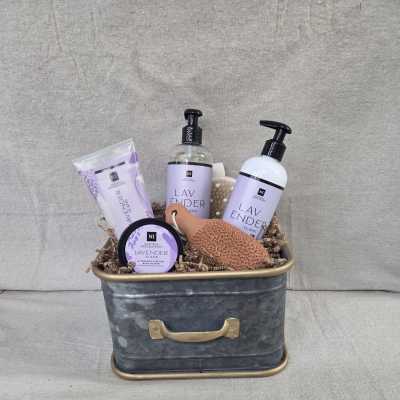 Lavender-scented bath and body gift set in a metal tin with bottles, tube, jar, and sponge
