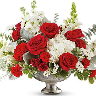 Red roses and white flowers in a silver pedestal vase
