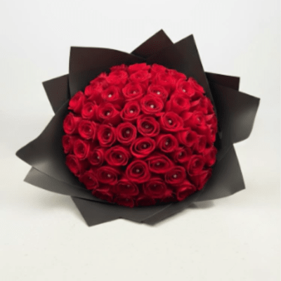 Round bouquet of red roses wrapped in black paper