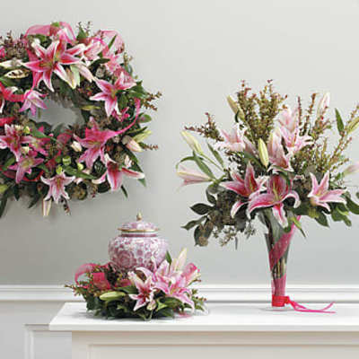Pink lily arrangements with a wreath, bouquet, and vase centerpiece