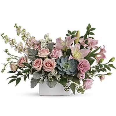 Pink roses and lilies arranged in a white box with greenery