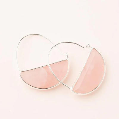 Pair of silver hoop earrings with pink semi-circle stones on a light background