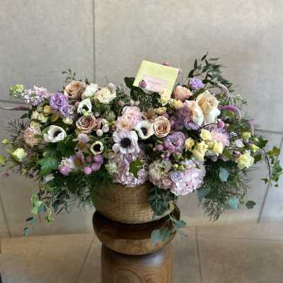Large pastel flower arrangement in a woven basket