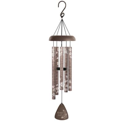Brown metal wind chime with white floral patterns and inscription hanging from a hook