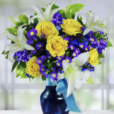 Yellow roses and purple daisies in a blue vase with white lilies