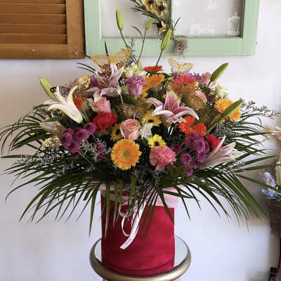 Mixed bouquet in a red hatbox with lilies, roses, and gerbera daisies