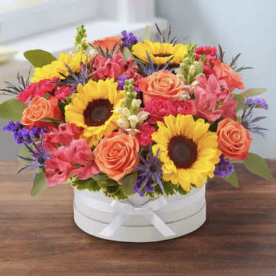 Bright mixed bouquet in a white round box with a ribbon