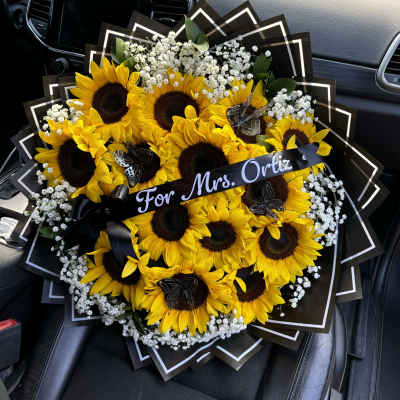 Bouquet of sunflowers and baby's breath with a black ribbon