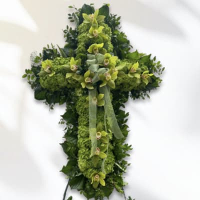 Green floral cross with orchids and ribbon on a white background