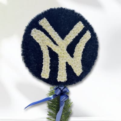 Round floral tribute with a white monogram on a dark blue background