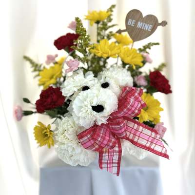 Bouquet of white and yellow flowers with a pink ribbon and "Be Mine" sign