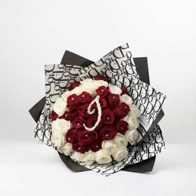 Bouquet of red and white roses wrapped in black-and-white patterned paper