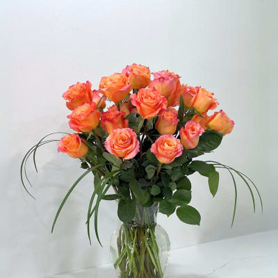 Bouquet of orange-pink roses in a clear glass vase