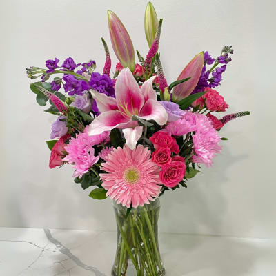 Pink and purple mixed bouquet in a clear glass vase