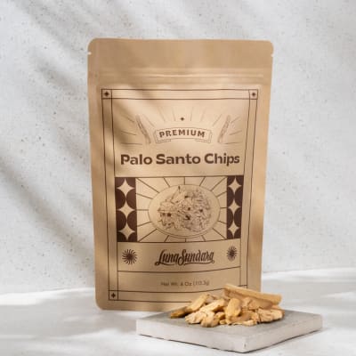 Bag of palo santo chips with loose wood pieces on a small block