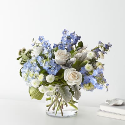 Blue and white flower arrangement in a clear glass vase
