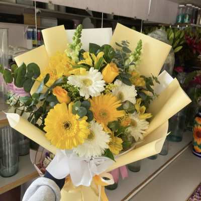 Yellow and white gerbera bouquet wrapped in pale paper