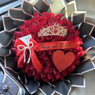 Red rose bouquet with a tiara and ribbon in a car seat