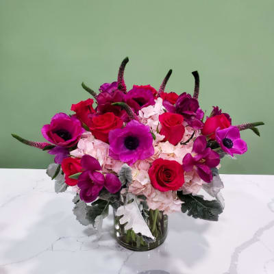 Pink and purple flower arrangement in a glass vase