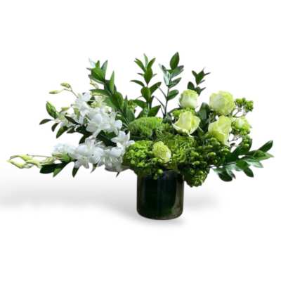 White and green floral arrangement in a dark glass vase