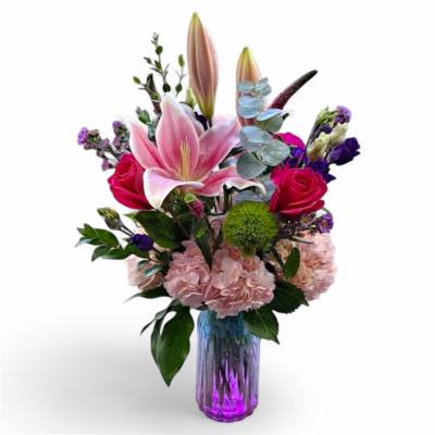 Pink lilies and roses in a purple glass vase