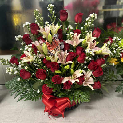 Large bouquet of red roses and pale lilies with a red ribbon