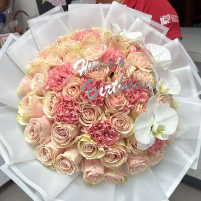 Pink rose bouquet with white orchids and a birthday topper