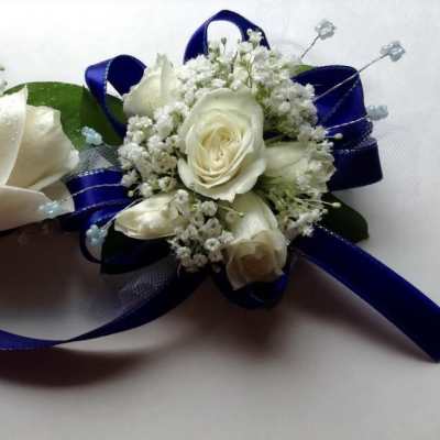 Two white rose boutonnieres with blue ribbon accents