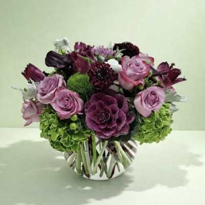 Pink and purple rose arrangement in a striped glass vase