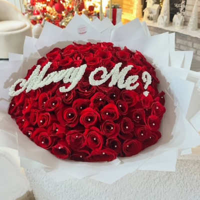 Large bouquet of red roses with white "Marry Me!" lettering