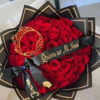 Heart-shaped bouquet of red roses with black wrapping and gold accents
