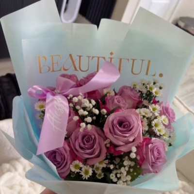 Bouquet of pink and lavender roses with small white filler flowers