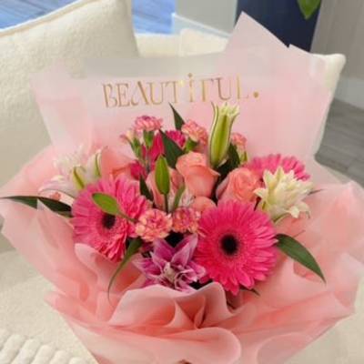 Pink mixed flower bouquet wrapped in pale pink paper