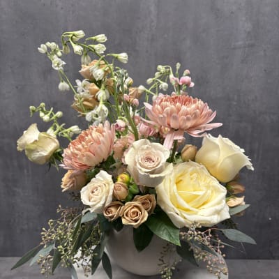 Pastel bouquet of roses and chrysanthemums in a white vase