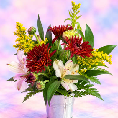 Mixed bouquet of red and white flowers in a metal bucket