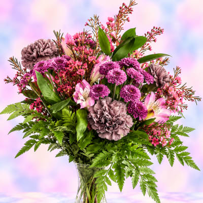 Pink and purple mixed bouquet in a clear glass vase