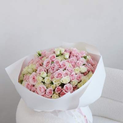 Large bouquet of pink and white roses wrapped in white paper