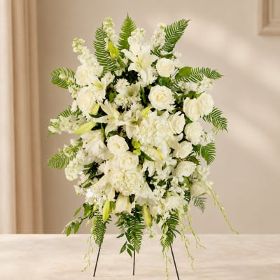 White floral standing spray with roses and lilies on a tripod easel