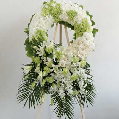 White and green funeral wreath on a wooden easel