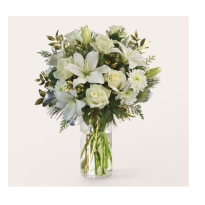 White lilies and roses arranged in a clear glass vase